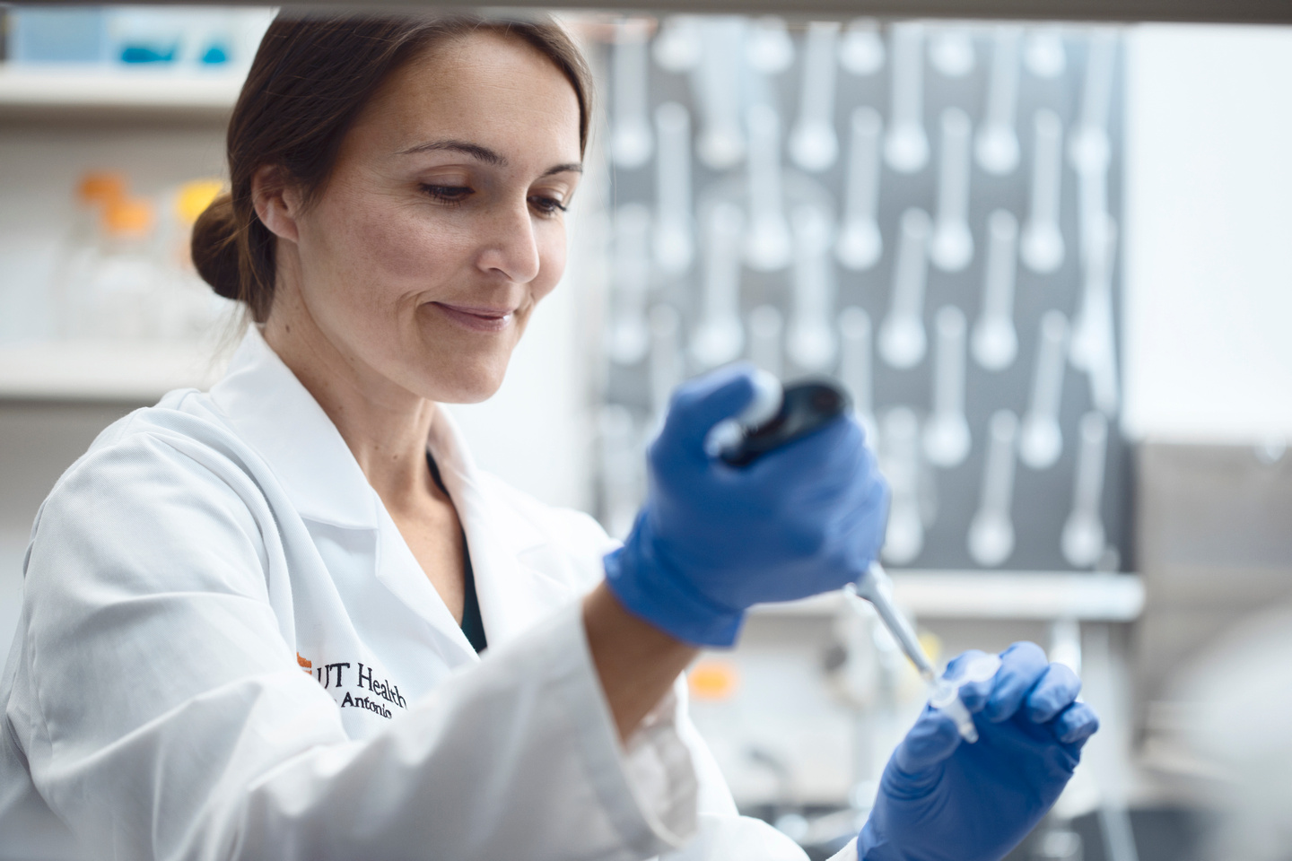 Dr. Bess Frost using a dropper in a lab. 