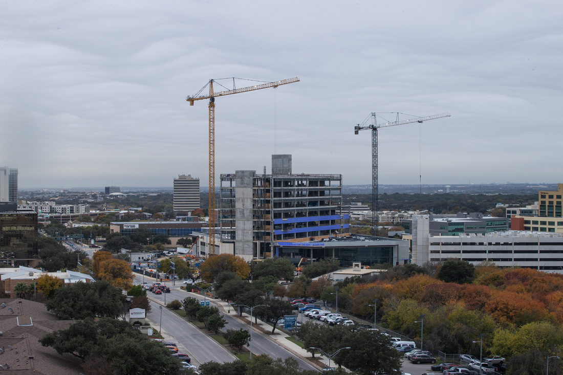 Cranes in a skyline over a construction project.