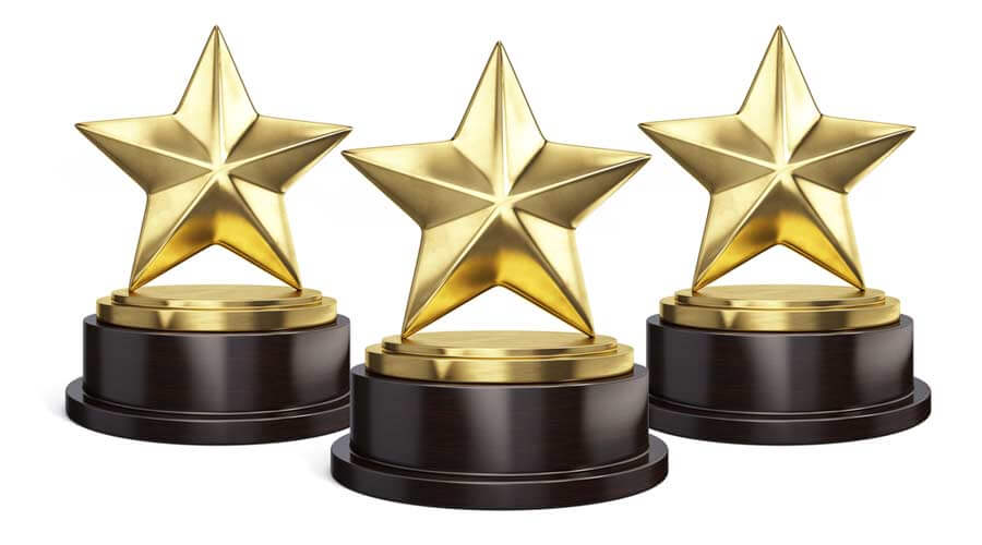 Stock image of three trophies in the shape of stars.